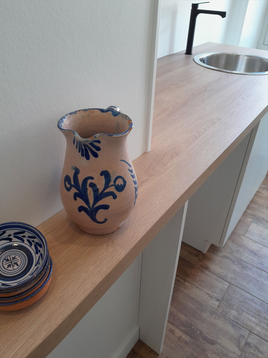 the laundry room after the work, with the custom-made creation of a cabinet including the washing machine and sink